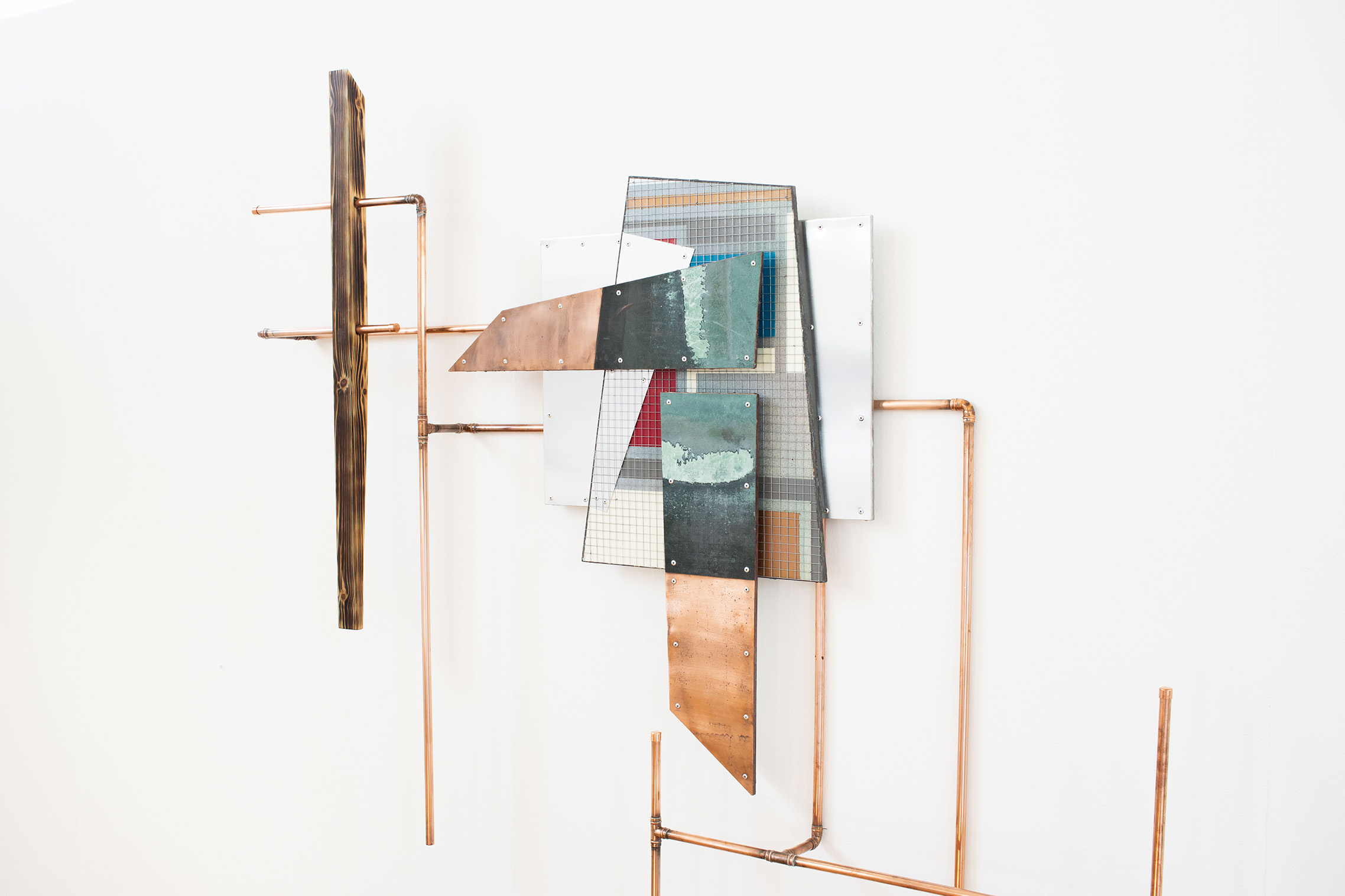 Industrial mixed-media wall sculpture with copper piping