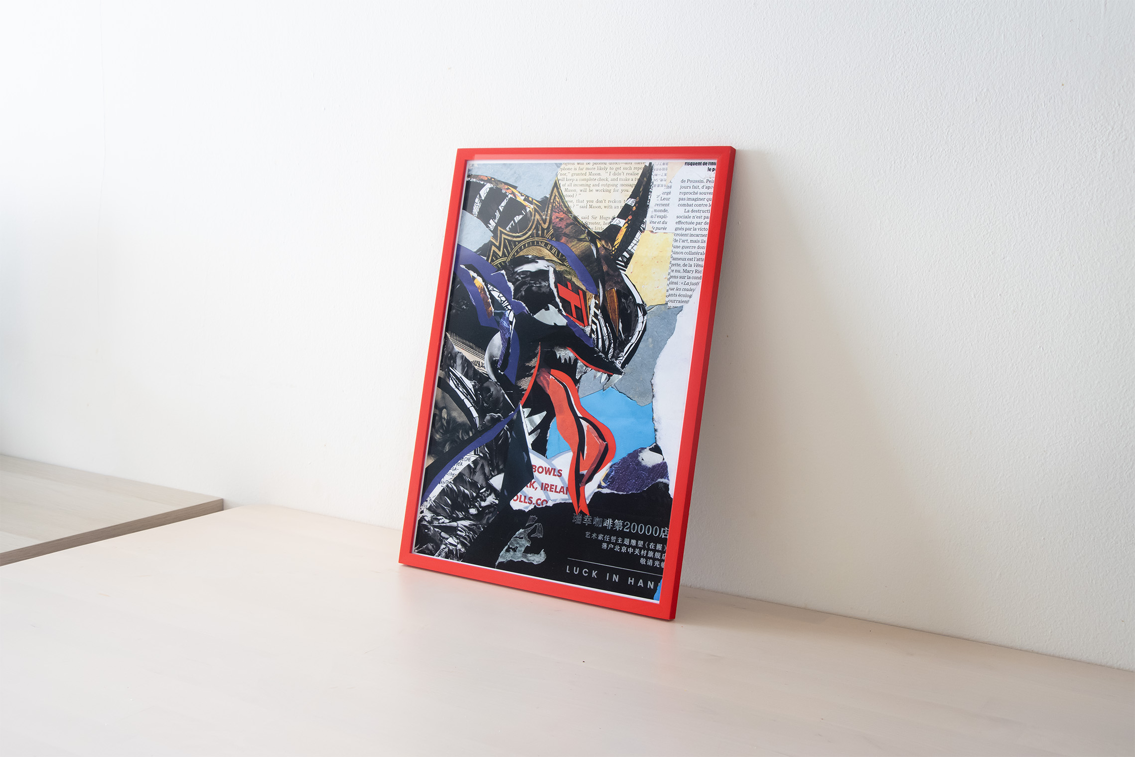 Collage artwork in a red frame, studio documentation